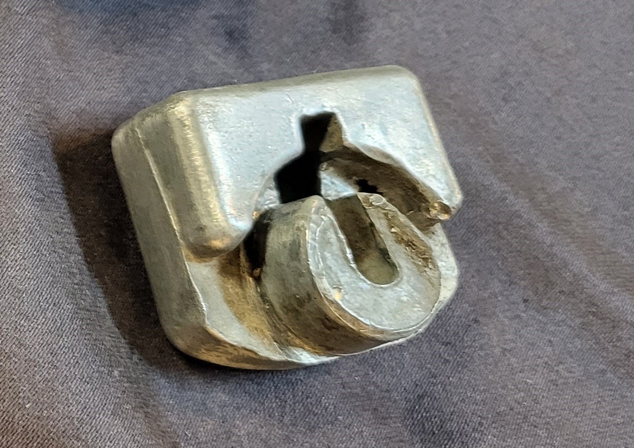 deformed metal e9 hood hinge block.jpg