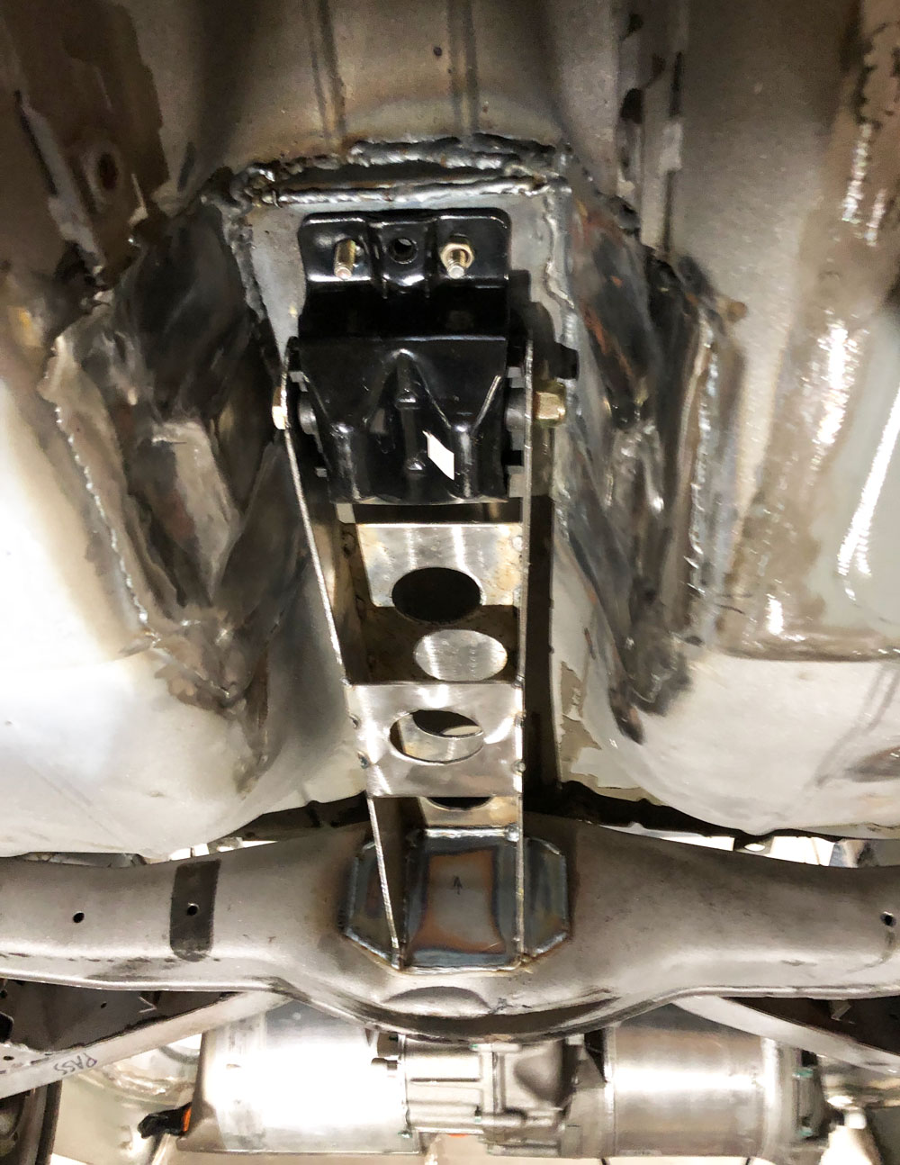 Looking front to rear, the subframe extension extends forward. Notice the Tesla unit in the rear, at the bottom of the photo.